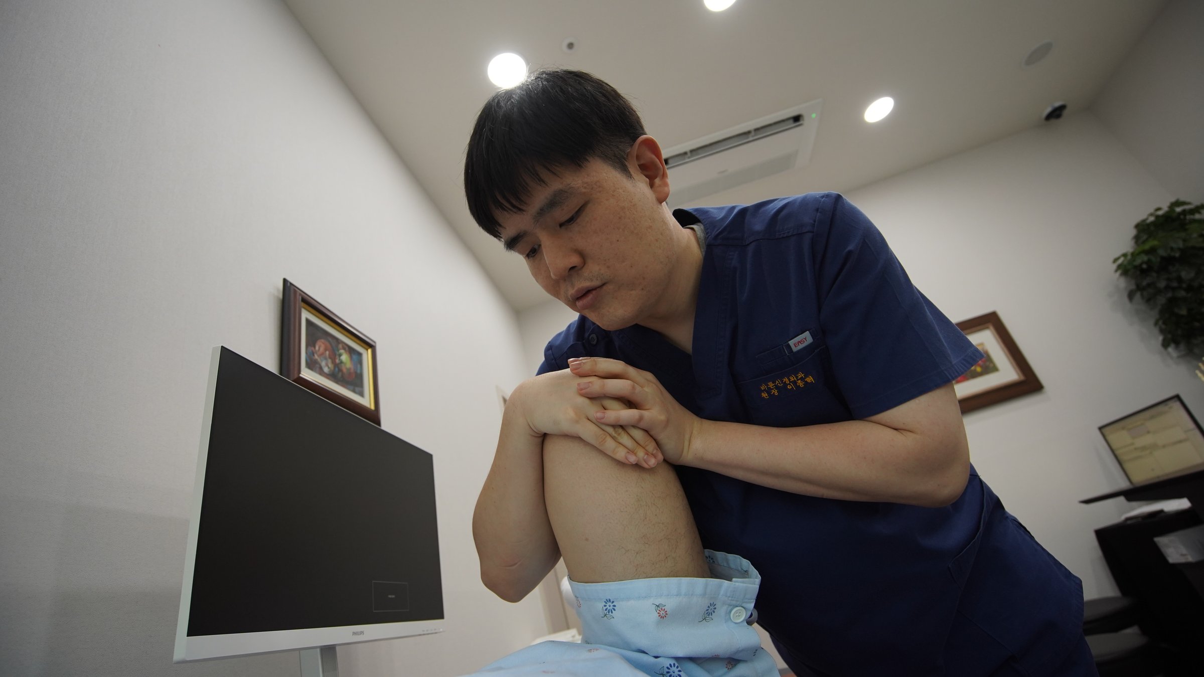 관절을 움직이며 증상과 구조 변화를 함께 확인하는 진찰 장면