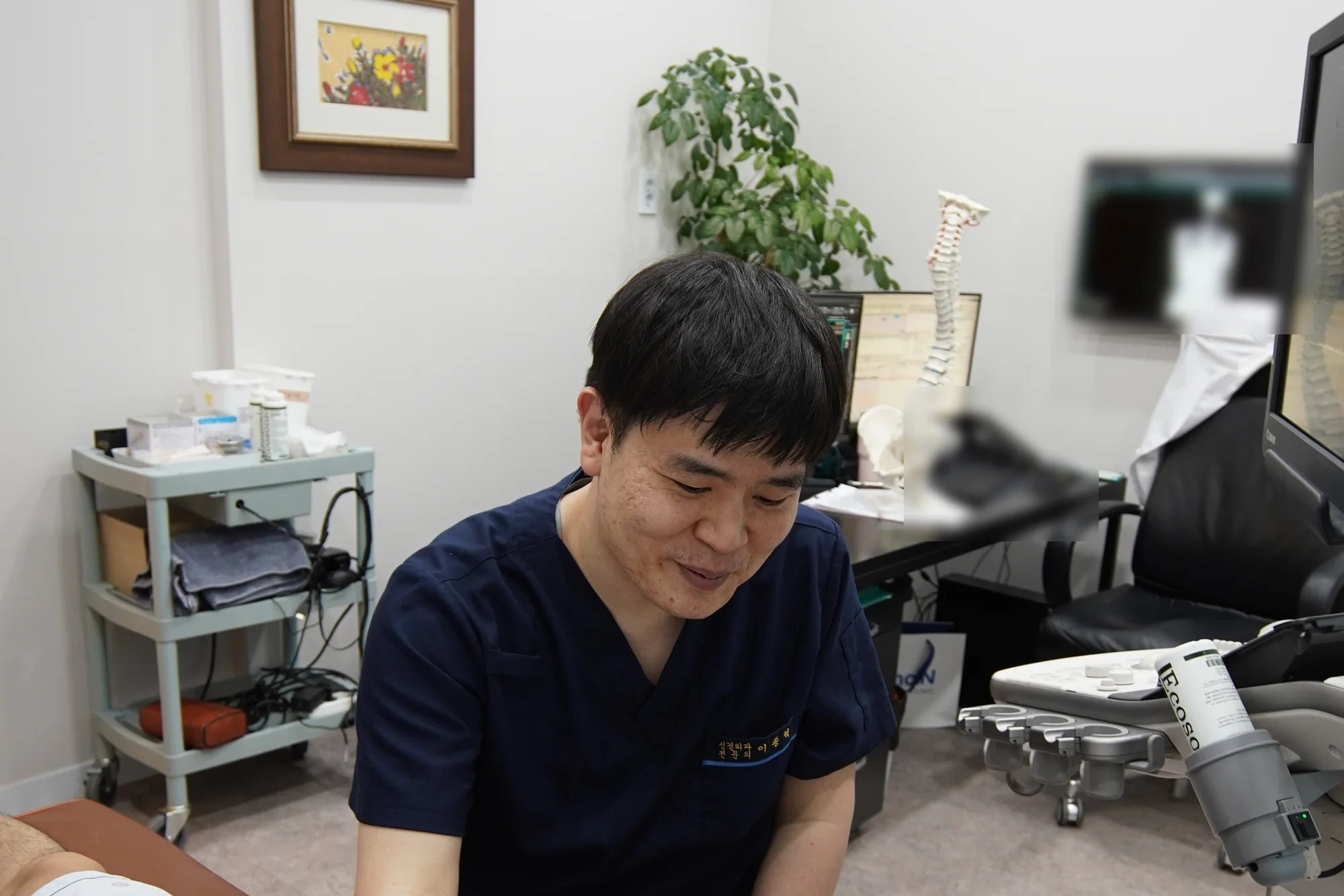 진료실에서 환자의 팔에 초음파 프로브를 대고 검사하는 의료진의 모습